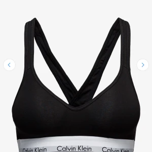 Svart linnetopp från Calvin Klein - Svart linnetopp från Calvin Klein med breda axelband som korsas i ryggen och vit resår med logga under bysten. Tillverkad i mjuk bomullsblandning med modal och elastan för extra stretch och komfort. Perfekt för en sportig och chill look.