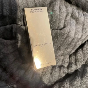 Rebecca Stella Flawless Foundation - HELT NY OANVÄND‼️Flawless Foundation från Rebecca Stella Beauty i en lyxig guldfärgad förpackning. Kommer i en 30 ml pumpflaska med svart lock. Färgen ser ut att vara medium till varm ton, perfekt för en naturlig och jämn bas. Snygg design som känns exklusiv och modern.