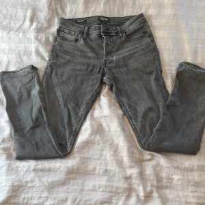 Grå slim jeans från Jack & Jones - Snygga grå jeans från Jack & Jones i modellen Slim/Glenn. Jeansen har en slim passform, klassisk femficksdesig. Perfekta för dig som gillar en smal siluett och stilren look. Priset går att diskutera vid snabb affär.