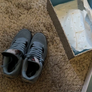 Nike Air Jordan 4 Retro University Blue - Säljer ett par Nike Air Jordan 4 Retro University Blue. Skorna är i ljusblå mocka med svarta och grå detaljer, meshpaneler och klassisk snörning. Ikonisk Jumpman-logga på plösen och hälen. Perfekta för dig som vill sticka ut med en snygg och sportig look.