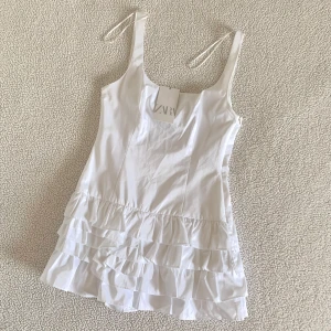 ZARA viral vit klänning med volanger - Otroligt snygg klänning från ZARA med volanger. Klänningen har inbyggda shorts på insidan. Ny med prislappar, utan anmärkningar. Ordinariepris 499kr.