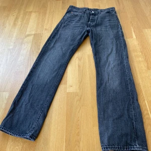 Levi's 501 washed black jeans straight fit - Klassiska Levi's 501 jeans i washed svart tvätt med straight fit. De har fem fickor, knappgylf och den ikoniska läderpatchen bak. Jeansen är tillverkade i slitstarkt bomullsjeansmaterial och har en tidlös look som funkar till allt. Perfekt för dig som gillar enkel och clean stil. I ett helt felfritt och perfekt skick! Storlek 30/32. Nypris: 1299kr Mitt pris: 699kr. 