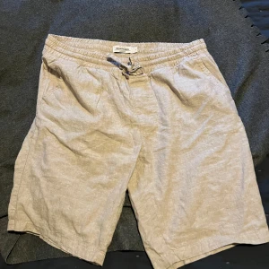 Beige linneshorts från Dressmann i Large - Snygga beige shorts från Dressmann i linnemix med elastisk midja och snörning. De har en avslappnad passform och är perfekta för varma dagar. Klassisk design med fickor på sidorna och mjukt material som känns chill mot huden. Nyskick. 