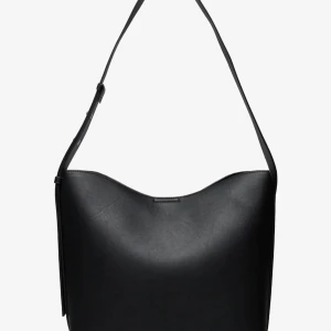 Svart axelväska  - Stilren svart axelväska i slätt skinn med justerbart axelband. Väskan är ca 30 cm hög och har en enkel, minimalistisk design. Invändigt finns ett fack med dragkedja för extra säkerhet. Perfekt för dig som gillar en clean look och vill ha plats för allt du behöver. HELT NY OCH KOSTAR 499KR NY.