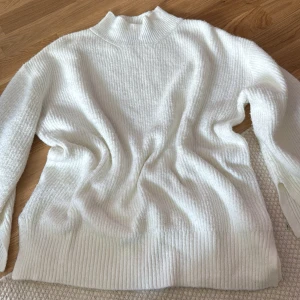 Vit stickad polotröja - Mysig vit stickad polotröja med ribbade muddar och hög krage. Perfekt för lager-på-lager och har en klassisk, enkel look som funkar till allt. Långärmad och i mjukt material som känns skönt mot huden.