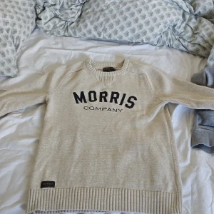 Beige stickad tröja från Morris XS - Beige stickad tröja från Morris Company i storlek XS. Tröjan har svart broderad logga framtill, ribbade muddar och rund halsringning. Pris kan diskuteras 