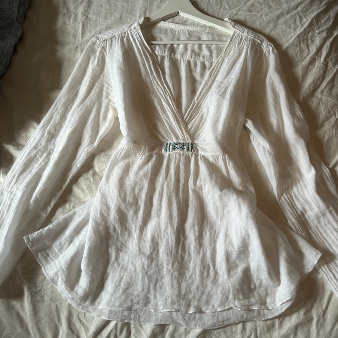 Vit blus med pärldetalj och knyt