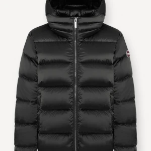 Svart dunjacka från Colmar - Säljer en svart, puffig dunjacka från Colmar med huva och dragkedja framtill. Jackan har en clean look med diskret logga på ärmen och breda, quiltade sektioner. Perfekt för kalla dagar när du vill hålla stilen enkel och snygg. Den är i minsta storleken men passar säkerligen även XS & S. Super fint skick, priset går möjligtvis att diskutera. 