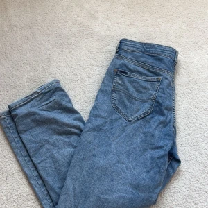 Blå jeans från Lee, rak modell - Klassiska blå jeans från Lee med raka ben och normal passform. Jeansen har fem fickor, snygga kontrastsömmar och Lee-logga på knappen. Perfekta för dig som gillar en tidlös och avslappnad stil. Model lee0012 i färgen bleach wash