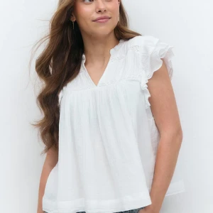 Vit blus med volangärm från Gina Tricot - Supersöt vit blus från Gina Tricot med volangärmar och v-ringning. Lätt och luftig i bomull, perfekt för varma dagar. Fina broderade detaljer upptill och lös passform. 
