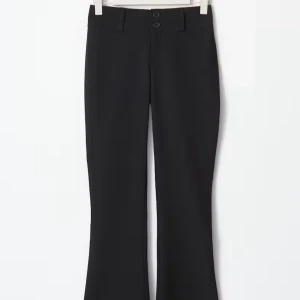 Svarta bootcut kostymbyxor - Svarta kostymbyxor med bootcut-snitt och två knappar i midjan. Byxorna har hällor för bälte och en klassisk, stilren look. Perfekta för dig som gillar en tidlös och snygg siluett.