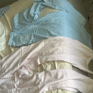 Pastellfärgade linnebyxor från Grunt - Två par luftiga linnebyxor från Grunt i storlek S. Ena paret är ljusblått och det andra ljusrosa, båda med resår i midjan för skön passform. Perfekta för varma dagar och chill vibes. Säljes tillsammans eller var för sig! Köpte båda byxorna för 1000 kr säljare för 500 för båda.