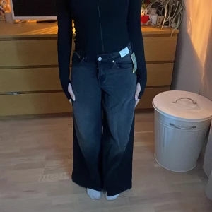 Svarta wide jeans från H&M, stl 158 - Säljer ett par svarta wide leg jeans från H&M i storlek 158. Byxorna har midwaist, raka vida ben och klassisk femficksmodell. Materialet är en mix av bomull och TENCEL Lyocell, varav 20% är återvunnen bomull. Snygg tvättad look och riktigt sköna.
