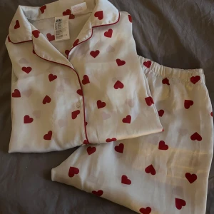 Sidenpyjamas - Jättegullig pyjamas med hjärtan som jag verkligen älskar!!❣️Men den har tyvärr blivit för liten. Nästan inga defekter och i mycket bra skick. Så fin och kan diskutera pris🥰