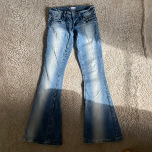 Blå bootcut jeans med låg midja - Säljer ett par snygga blå bootcut jeans med låg midja. Dem är mjuka och sköna! Använda ungefär 5 gånger. Priset är förhandlingsbart. Priset är ink frakt. Dem är från Gina Tricot +14 