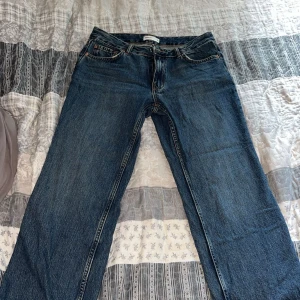 Blåa jeans från Gina Tricot.  - Säljer ett par klassiska blå jeans från Gina Tricot med rak passform i mid waist. Jeansen har fem fickor, bälteshällor och stängs med dragkedja och knapp. Perfekta till sneakers eller boots för en chill look. Använda en gång, men inga tecken på användning eller defekter så därav är de som helt nya. Storlek 36.