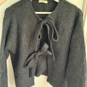 Stickad kofta - Super söt svart kofta man knyter från Gina i storlek XS. Passar S också, brukar ha XS/S. Väldigt mjuk. Använd fåtal ggr så i bra skick!  Kom med prisförslag, allt ska bort!🌷