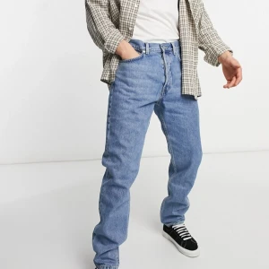 Weekday ljusblå jeans Pine - Jeans i ljusblå denim med avsmalnande ben och normal passform. Storlek 30/32