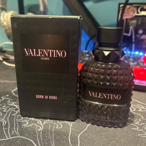 Valentino Uomo Born In Roma EdT 50ml - Valentino Uomo Born In Roma EdT 50ml. Flaskan är mörk och har en cool nitar-inspirerad design i glas med svart mattsvart kork. Snygg svart kartong med rosa text. Perfekt för dig som gillar exklusiva och moderna dofter. Ungefär 35 ml kvar! Pris kan diskuteras 