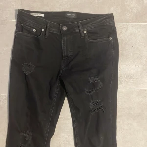 Svarta Jack & Jones jenas  - Svarta jeans från Jack & Jones. Jeansen har slitningar och väldigt fräsha.                        Hör av dig vid frågor eller mer bilder!!!