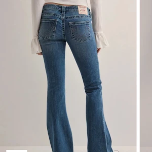Blå bootcut jeans från True Religion - Säljer ett par klassiska blå bootcut jeans från True Religion med ikoniska bakfickor och ljusa sömmar. Säljer på grund av att jag inte får några mer användning då jag har ett par likadan🤗