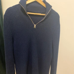 Mörkblå stickad half zip - Mörkblå ZARA half zip tröja med hög krage och dragkedja framtill. Är i fantastiskt skick utan några skador alls och ärPerfekt för kyligare dagar. Säljer då jag ej använder längre