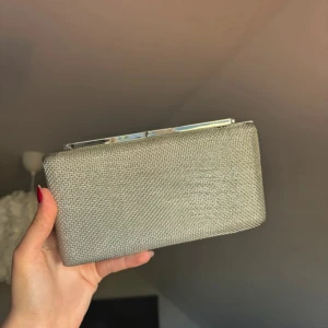 Silvrig clutch - Superfin silvrig kuvertväska! Helt ny med plast runt kedjan kvar. Köpt från Zalando. Perfekt till bal till exempel