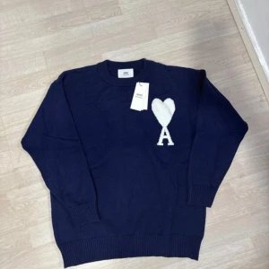 Mörkblå stickad tröja från Ami Paris - Säljer en mörkblå stickad tröja från Ami Paris. 10/10 skick aldrig använd då den ej passar. Påse tillkommer samt tags. 
