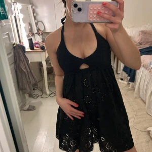 Svart klänning🫐 - Säljer en svart kortklänning med halterneck och broderade blommönster. Så snygg perfekt för sommaren och stranden!!!