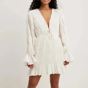 Moa Mattson - nakd  - Superfin vit kortklänning med v-ringning och omlottdetalj framtill. Från Moa Mattsons kollektion med Na-Kd, aldrig använd!