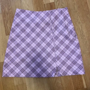 Lila rutig kjol från H&M y2k - Säljer en lila A-linjeformad kjol från H&M med rutigt mönster och liten slits framtill. Jätte fin till sommar och höst. Vid kallare dagar passar den perfekt till strumpbyxor och benvärmare. I storlek 158 men skulle säga att den passar xs-s också. #lila #y2k #bratz #gilmore #höst #kjol #aesthetic #brandymelville