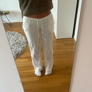 Vita linnebyxor - Säljer ett par vita linnebyxor med normal passform och dragsko i midjan. Byxorna har raka ben och sidfickor, perfekta för en avslappnad stil. Lätta och luftiga, passar bra till varmare dagar.