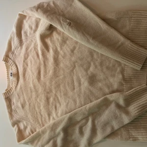 Beige stickad tröja från Uniqlo - Säljer en klassisk beige stickad tröja från Uniqlo.