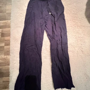 Mörkblå linnebyxor från Zara - Säljer ett par mörkblå linnebyxor från Zara med resår i midjan och dragsko. Byxorna har en lös och rak passform med fickor bak. Perfekta för varmare dagar och  sköna att bara ha . De är lite slitna där nere men var så när jag köpte dom. 