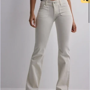 Vita lågmidjade bootcut jeans - Säljer dessa vita lågmidjade bootcut från Nelly! Lite tecken på användning men inget man märker tydligt!!! Mindre i storlek så passar M-L💕💕