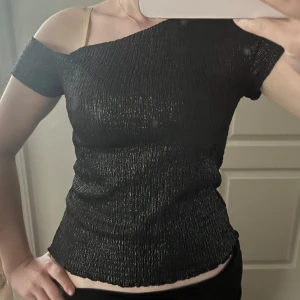 Svart glittrig topp - sjuuuukttt snygg topp som är glittrig och one shoulder fit❤️Strlk M, men sitter så fint på S också då materialet strechas, inga defekter o pris kan diskuteras