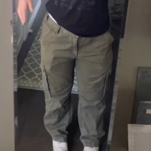 Gröna cargobyxor från Carhartt - Ett par olivgröna cargobyxor från Carhartt, relaxed fit med fickor på sidorna. Köpta i en vintage butik. Skulle säga att dom är Unisex. Storlek 36/30 i tumm - vilket motsvarar 90cm i midjemått (alltså runt om hela midjan) och ca 75cm i ben längd. Alltså typ storlek L. Snabb affär = lägre pris, skriv för frågor. 