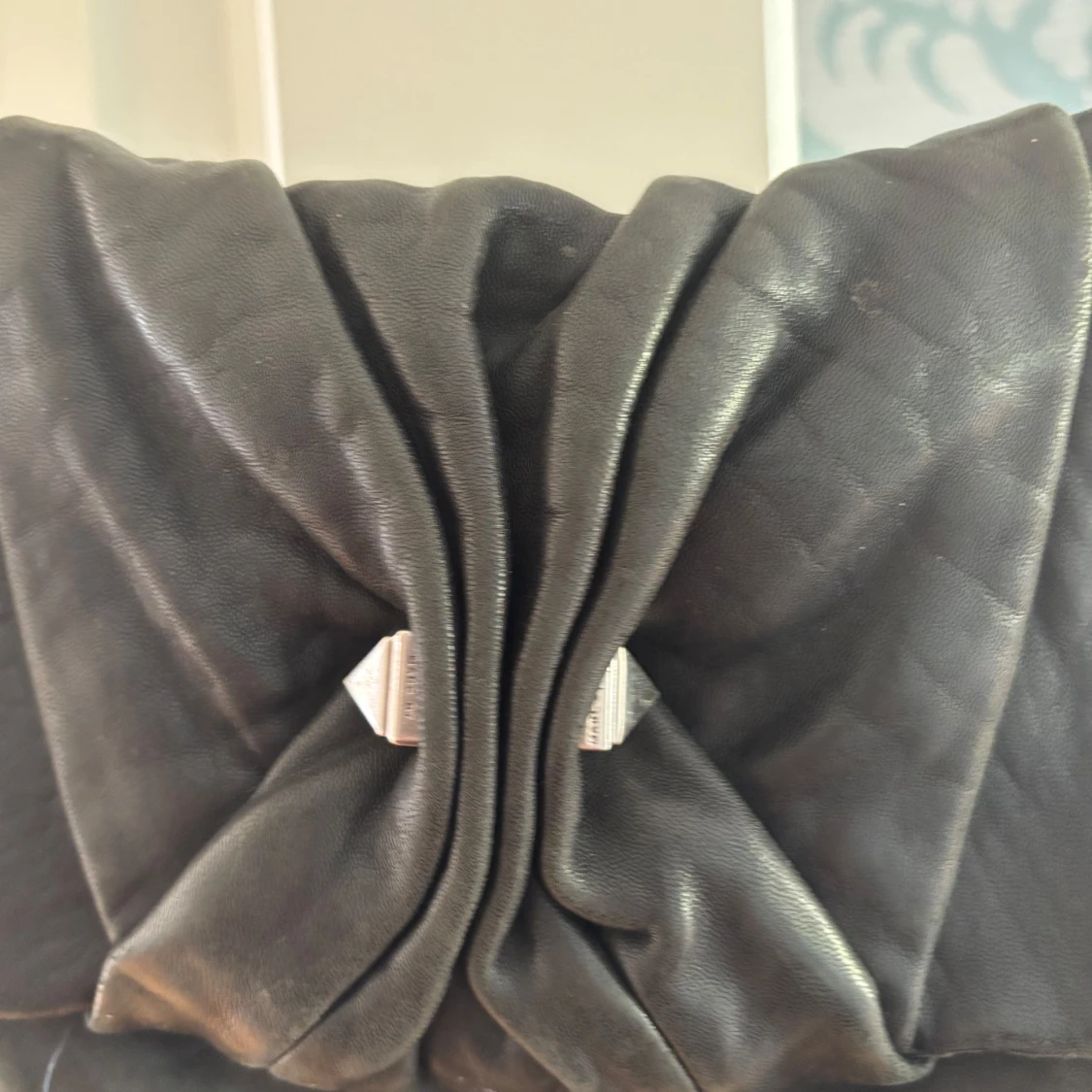 Svart axelväska med rosett och mönstrat foder