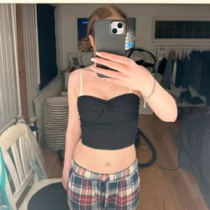 Svart croppad tubtopp - Säljer en svart croppad tubtopp med twistad detalj framtill. Toppen är ärmlös och har en enkel, stilren design som passar perfekt till sommaren.