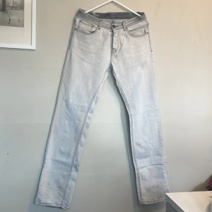 Ljusblå raka jeans - Säljer ett par ljusblå jeans med raka ben och klassisk fyrficksdesign. Jeansen har normal passform och stängs med dragkedja och knapp. Perfekta för dig som gillar en enkel och stilren look.