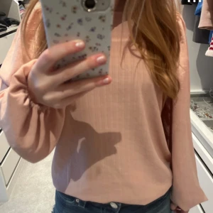 Ljusrosa blus med puffärm från VILA - Säljer en ljusrosa blus från VILA med rund halsringning och långa puffärmar. Blusen har en enkel och stilren design med lätt struktur i tyget och knapp i nacken. Perfekt att styla med jeans eller kjol. Ny utan prislapp💗💗