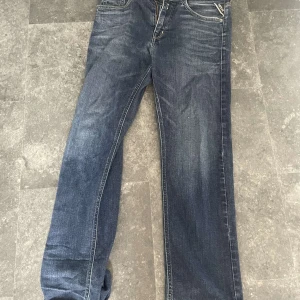 Mörkblåa replay jeans - Säljer ett par mörkblåa replay jeans. Jeansen har slim straight passform och är lite slitna från användning men fullt användbara och perfekta till sommarn.