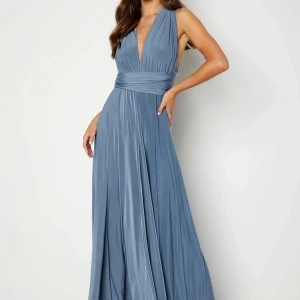 Multi tie maxi dress - Multi tie maxi dress i M, aldrig använd. Säljer så jag hittat en annan. Köpt för 1 299kr. -Stretchig kvalitet. - Knytdesign. -Justerbar passform. - Makerad midja. -Klänningens längd går även att klippa, då det är en rå kant nedtill. 