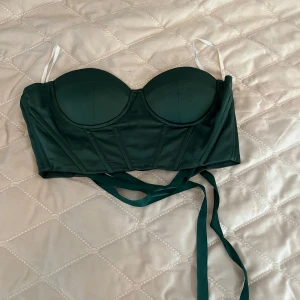 Grön korsettopp från SHEIN - Snygg grön korsettopp från SHEIN med bygel och snörning i ryggen. Perfekt att styla med jeans eller kjol för en trendig look.