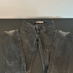Gråa lågmidjade Jeans  - Säljer ett par gråa lågmidjade jeansbyxor från Only. Byxorna har raka ben och subtila slitningar för en avslappnad look. Perfekta till vardags och lätta att matcha med olika toppar.