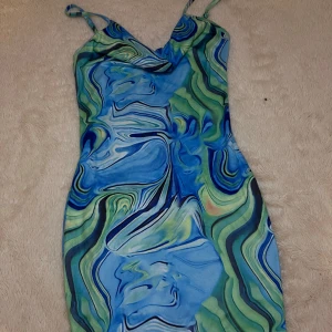 Blågrön mönstrad klänning💙💚 - Säljer en tight men stretchande snygg klänning med blått och grönt marmormönster. Klänningen har smala axelband och en lätt draperad v-ringning som man kan justera på de som passar en. Perfekt för dig som ska ut till en fest eller klubb och vill se extra men inte för extra ut. Storleken är xs men passar s också, pris kan diskuteras och om ni har andra frågor eller undrar om fler bilder💙