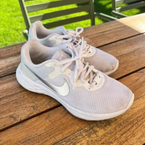 Vita springskor från Nike i storlek 37,5 - Säljer dessa springskor som knappt är använda i storlek 37,5, de är lite smutsiga på framsidan som syns på bilderna men annars är de i toppenskick!!