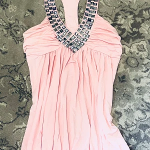 Ljusrosa linne med glittriga detaljer.  - Supersöt ljusrosa linne med nitar längs urringningen. 