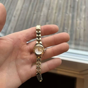 Guldklocka - Klockan är i ett mycket fint skick med ett sprillans nytt batteri och armbandet är justerbart så du enkelt kan justera armbandets originella storlek som är 19 cm.   Vid frågor och funderingar är det bara att skriva ✍️