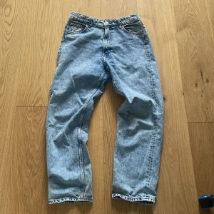Ljusblå loose-fit jeans - Säljer ett par klassiska ljusblå jeans med rak passform och normal midja. Jeansen har fem fickor, dragkedja och knapp framtill. Perfekta för en avslappnad stil och passar till det mesta. 